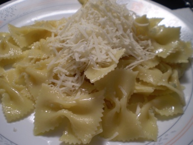 Bowtie pasta mixed with garlic and olive oil, garnished with freshly grated kefalotyri cheese.